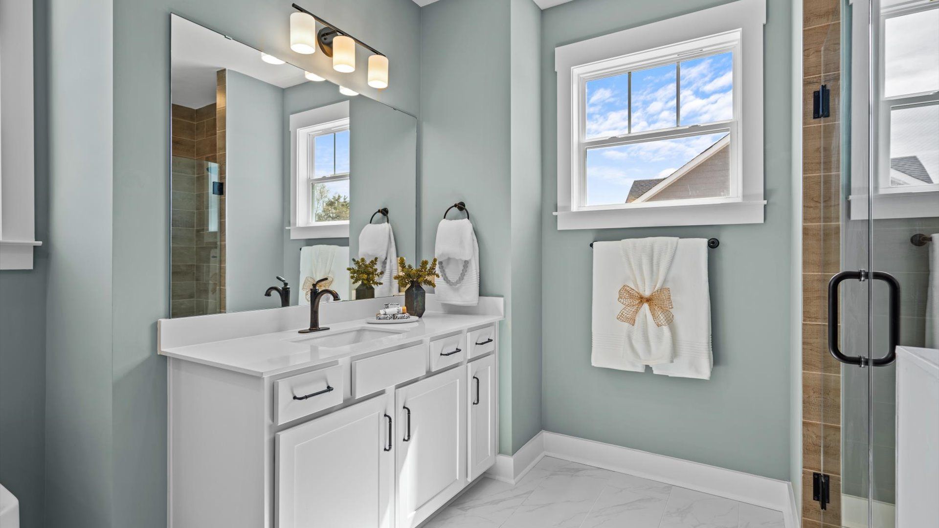 Exceptional en-suite with separate vanities and glass-enclosed walk-in shower for superior everyday comfort