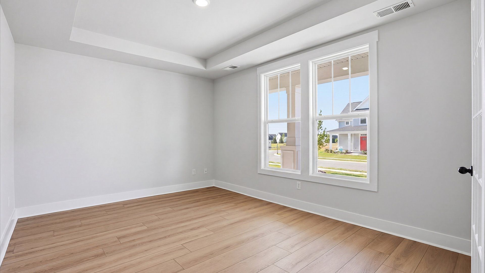 Vibrant natural light and tasteful design define this French door study near the front of the home at Benjamin's Grove