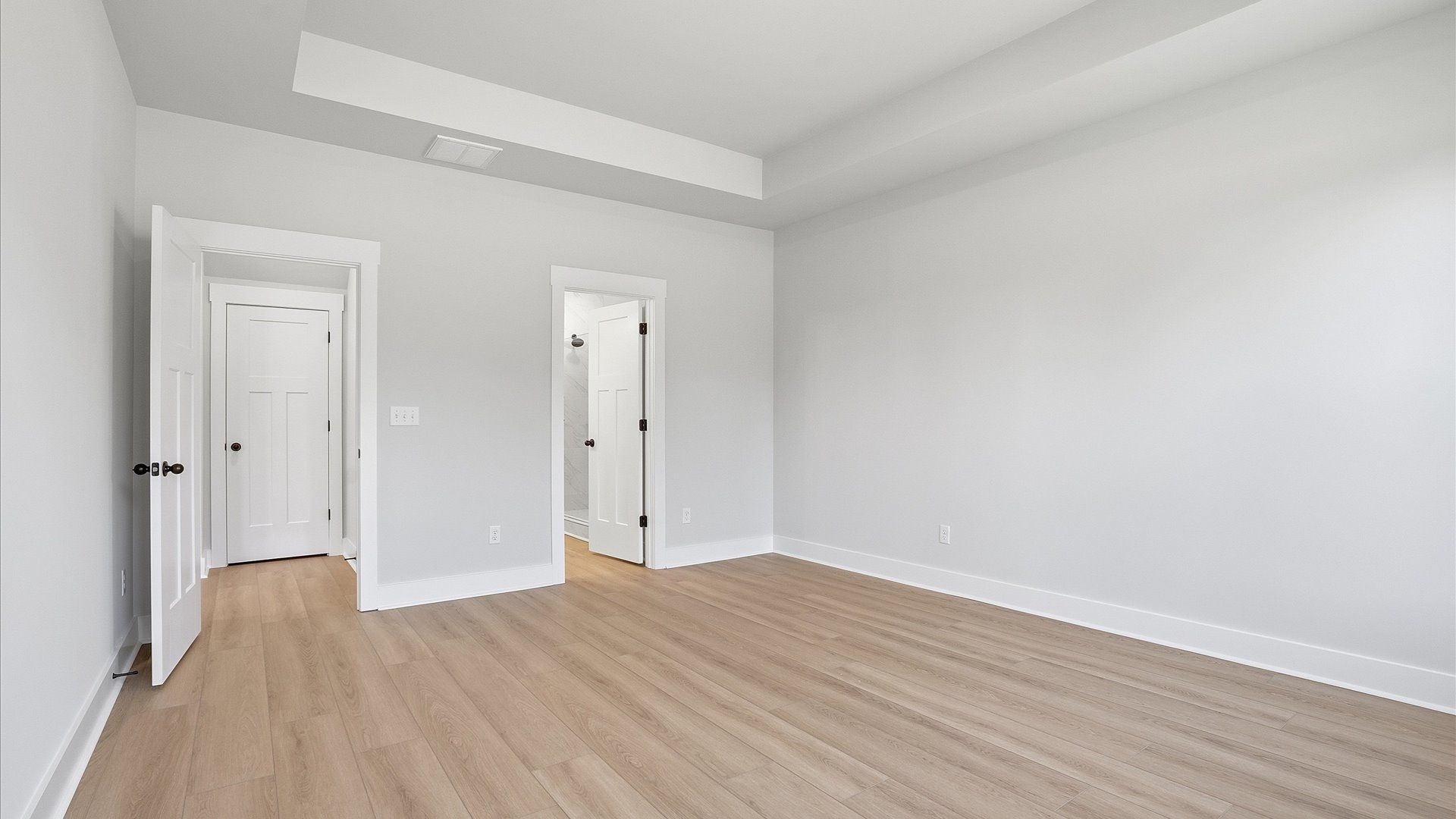 First-class hardwood floors and tasteful finishes elevate the private retreat of this exceptional primary suite in Woodruff