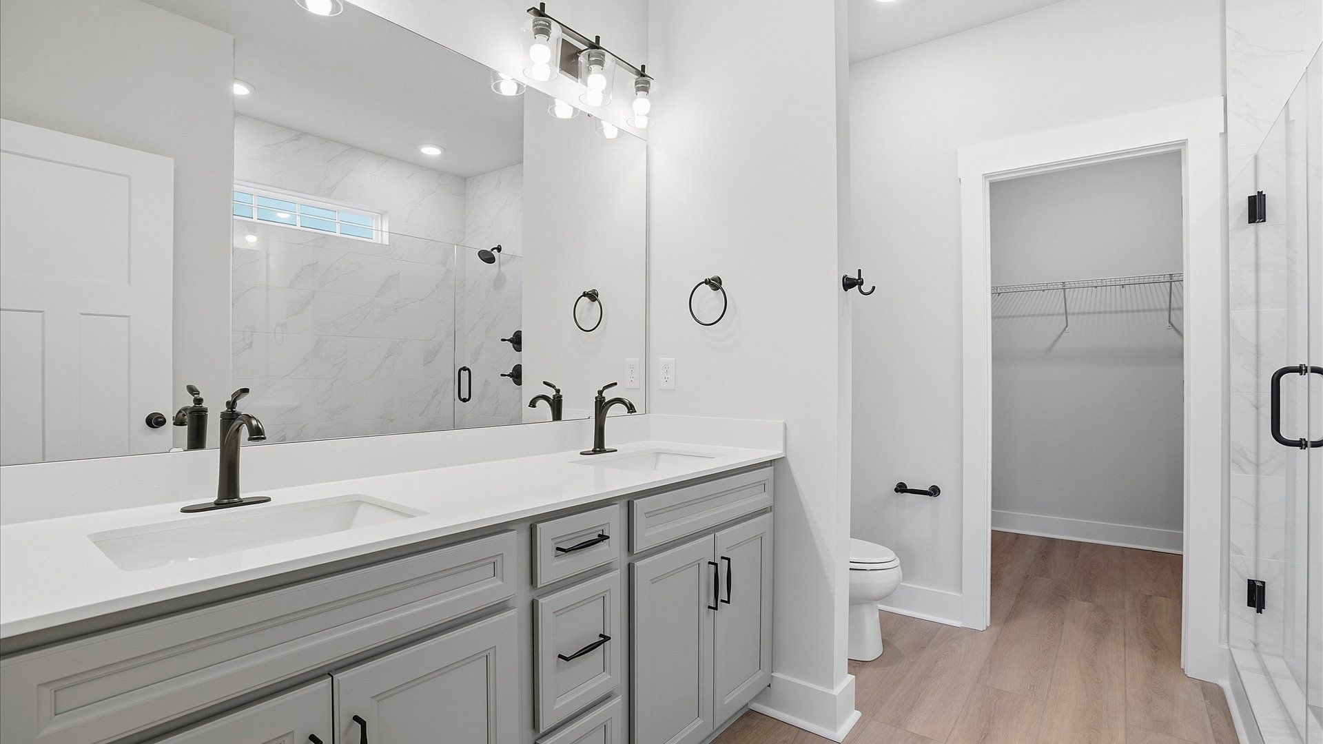 Highly functional and elegant en-suite with dual vanities, tiled walk-in shower, and refined finishes at Benjamin's Grove