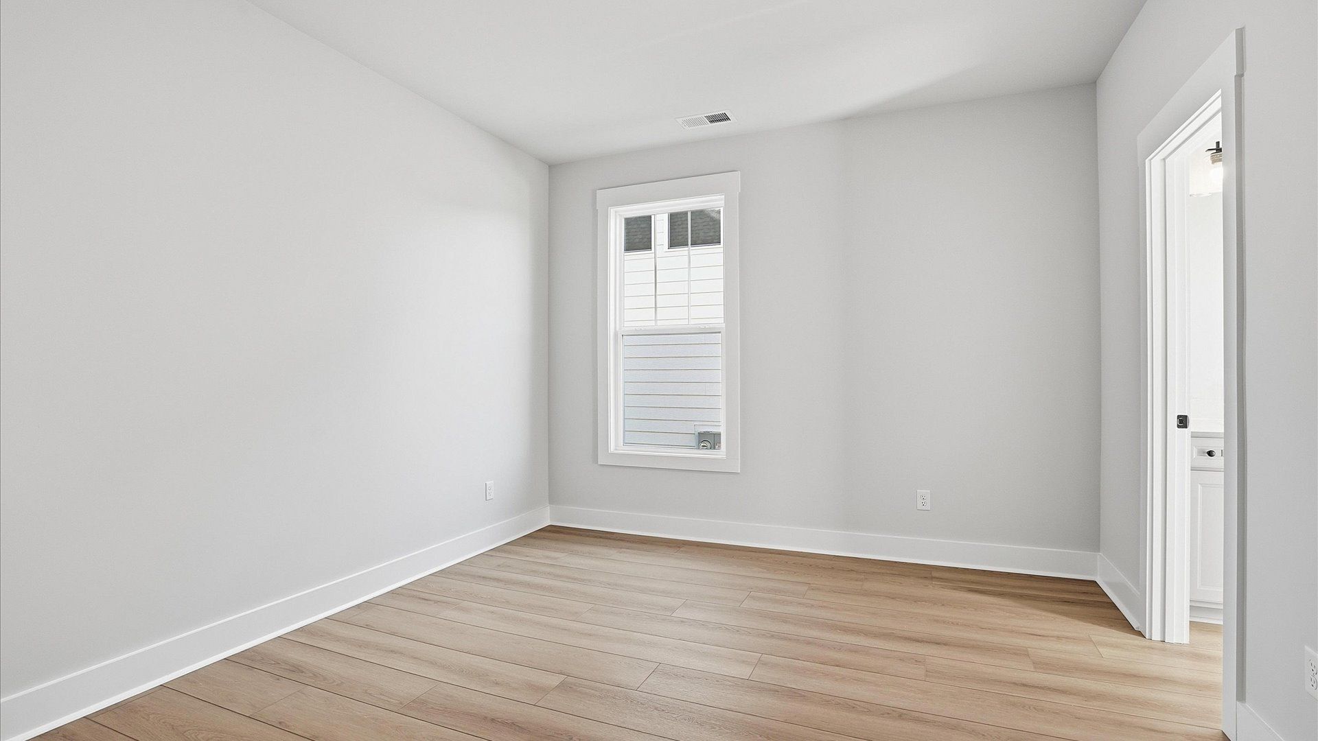 Superior hardwood flooring enhances the comfort and style of this secondary bedroom located at Benjamin's Grove