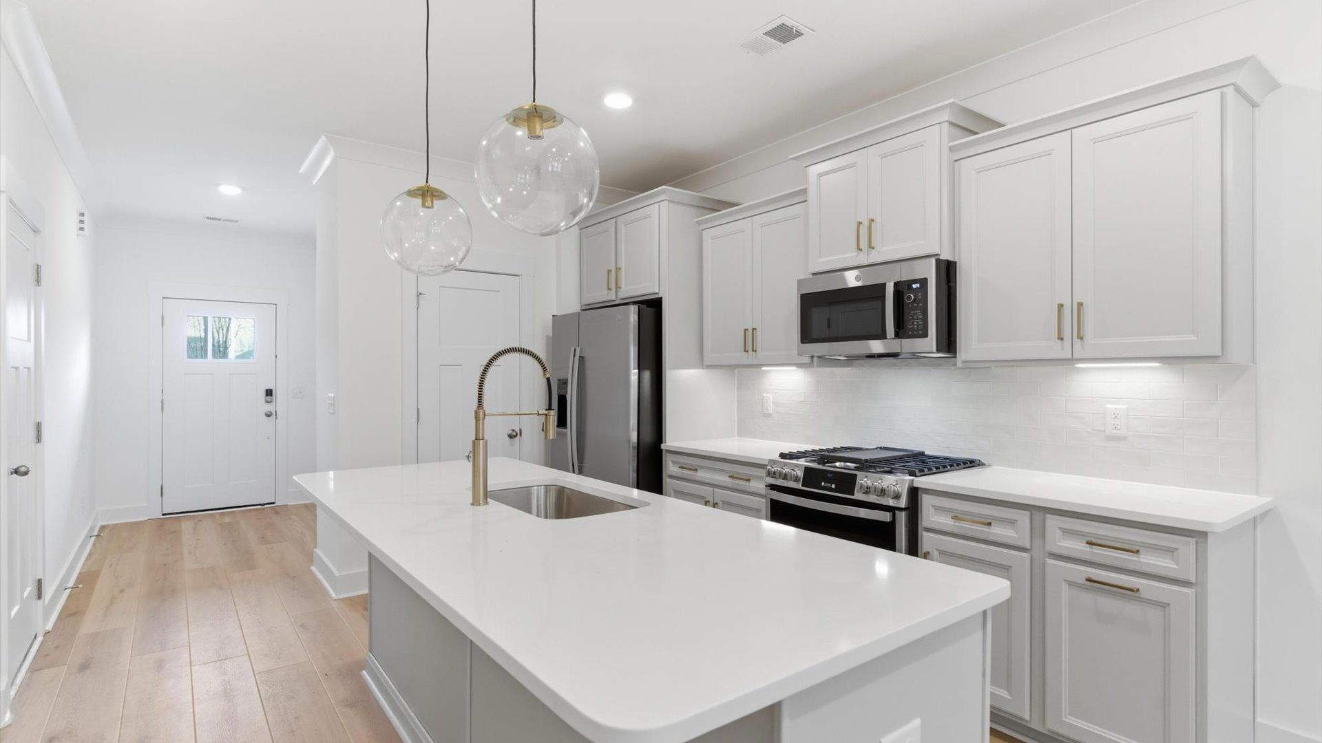 Superior kitchen with quartz countertops, pendant lighting, and a generously sized island