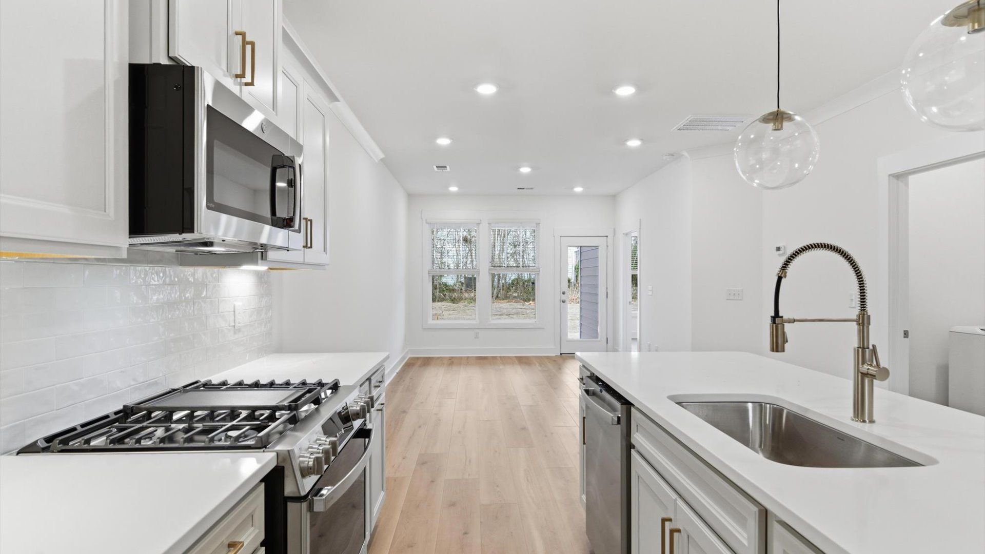 Highly skilled craftsmanship shines in this modern kitchen with pendant lighting and a central island focal point