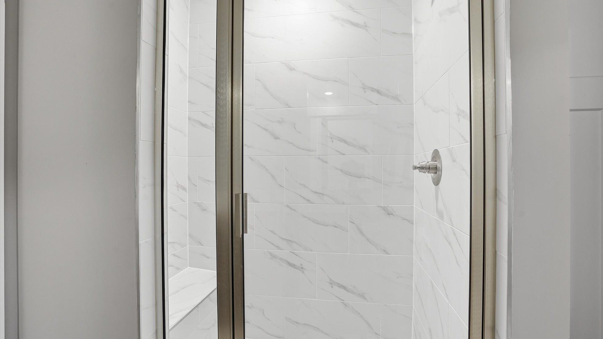 Memorable mornings begin in this elegant primary bathroom with a tiled walk-in shower at the new Anna's Pointe community