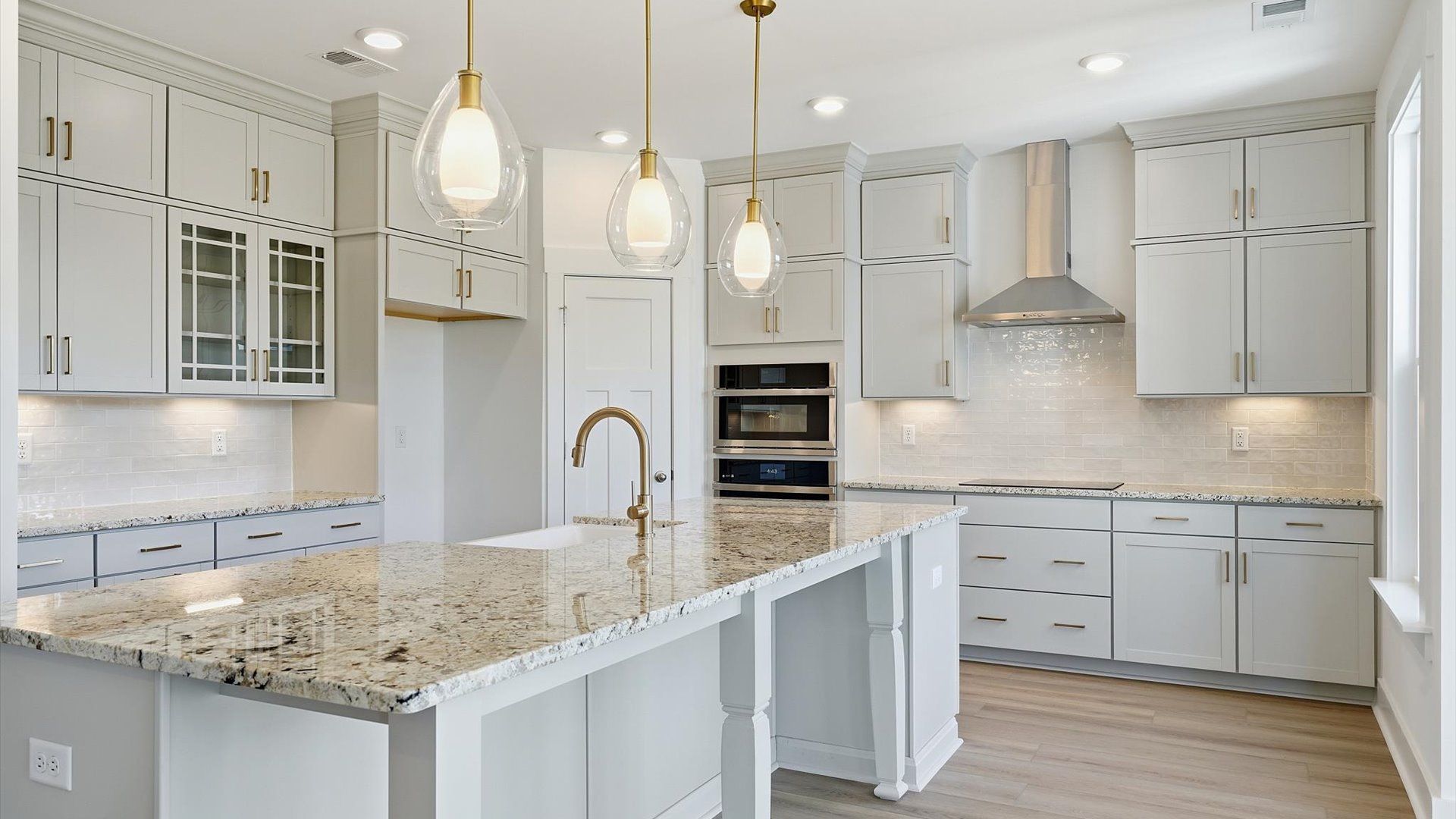 Vibrant and open kitchen centered around a 9-foot island with elegant pendant lighting above located in Woodruff, SC