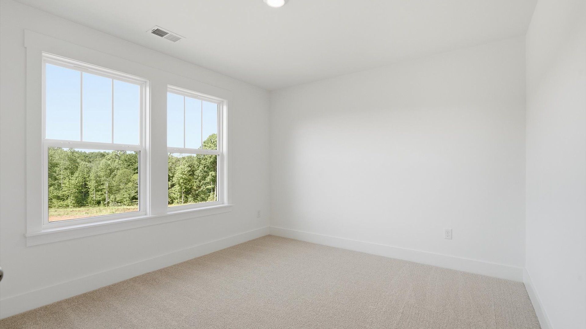 Tasteful bedroom with plush carpet, a walk-in closet, and large windows for abundant natural light at Pinebrook