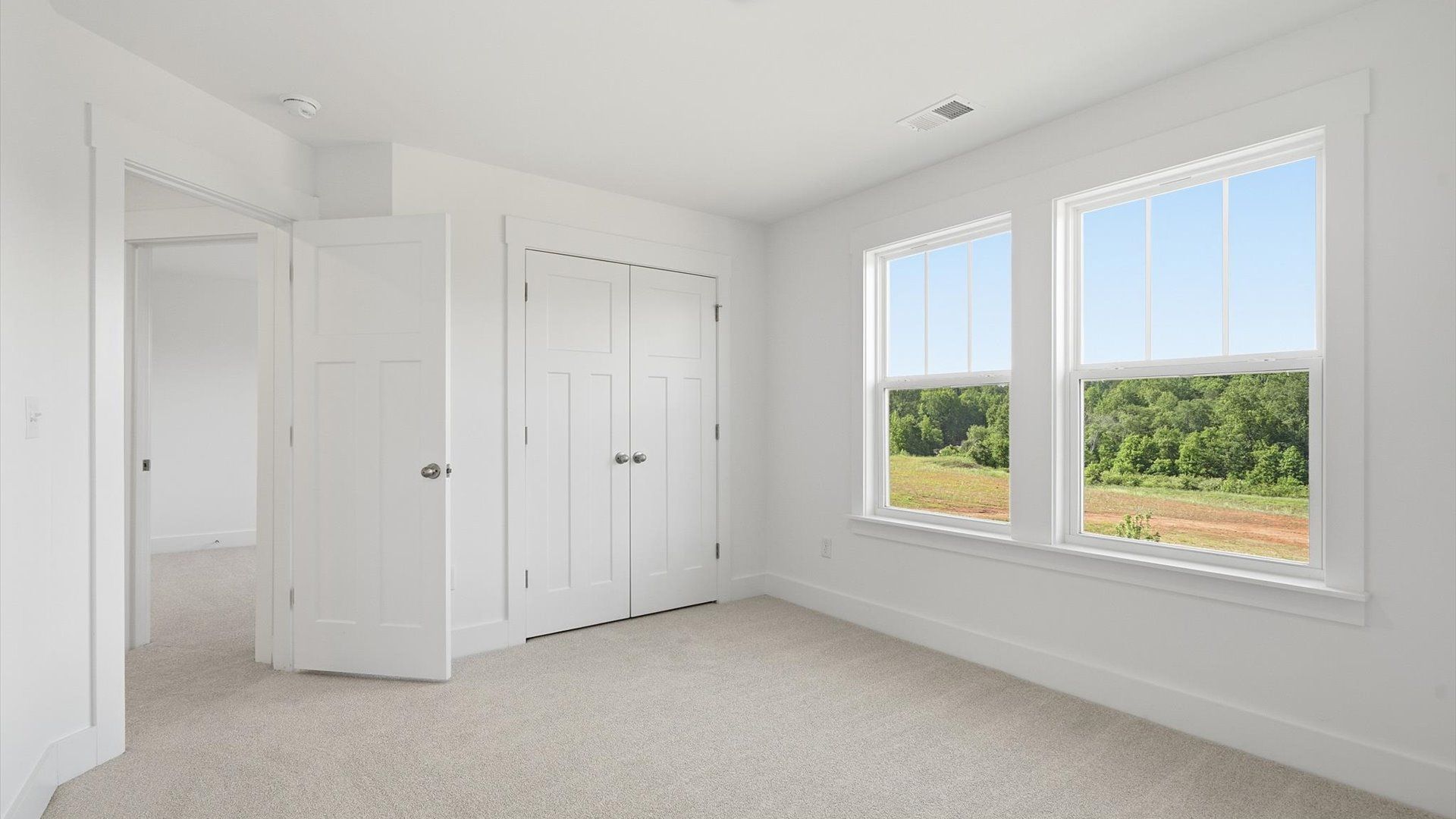 Highly functional bedroom with walk-in closet and tasteful carpet for a restful retreat