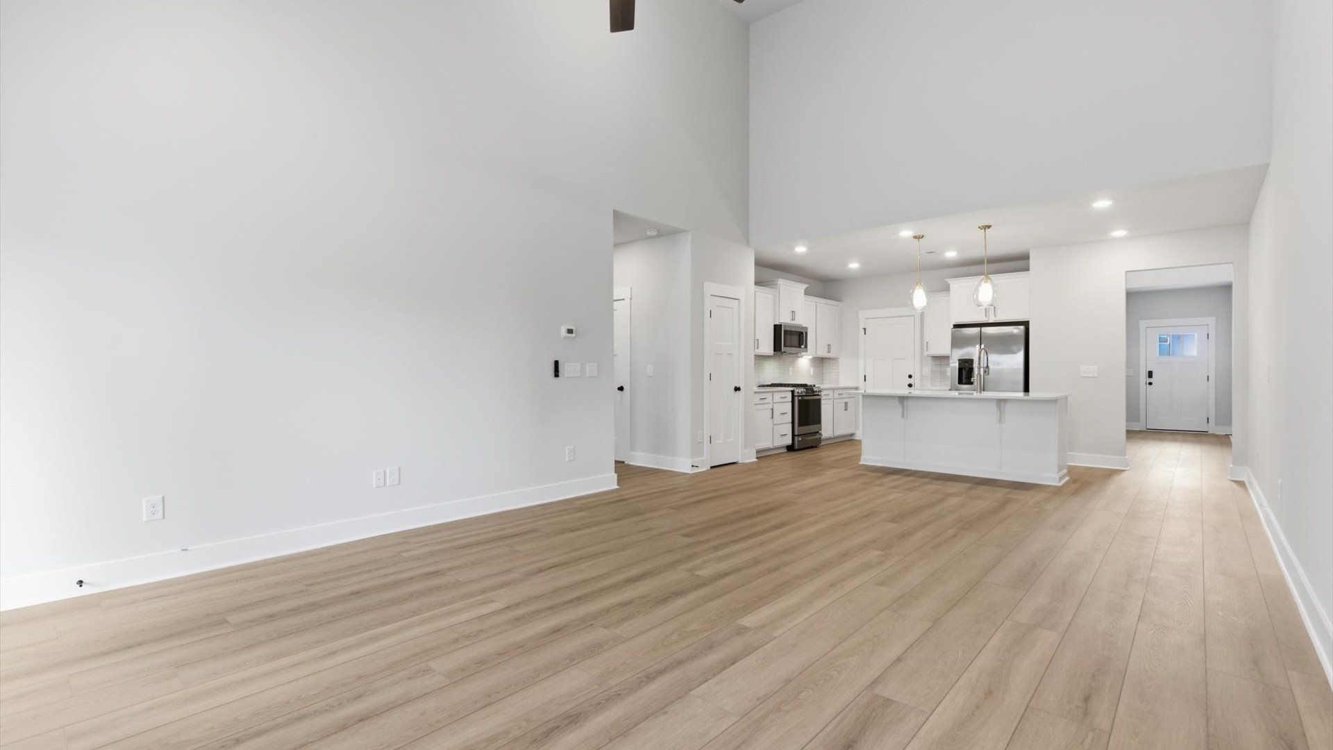 Spacious and stylish family room with two-story ceilings that create a bright and open atmosphere