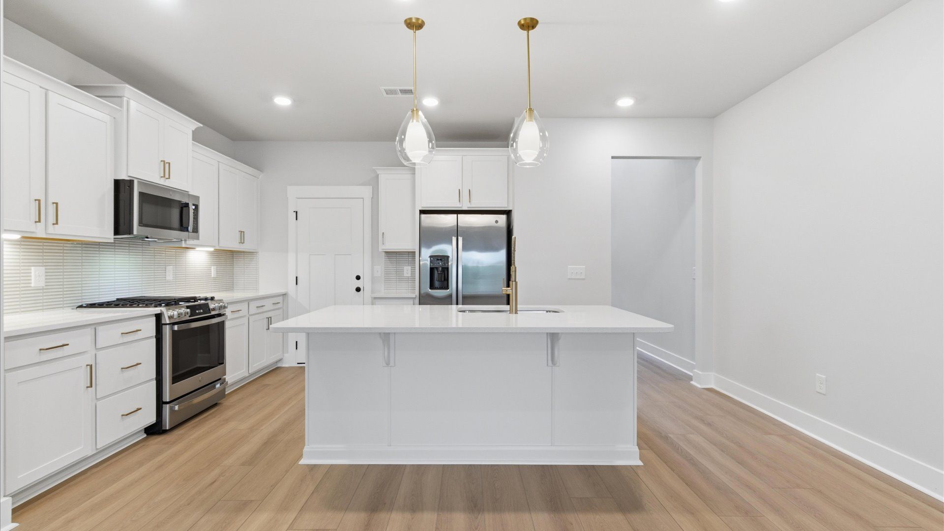 Exclusive kitchen design with a center island, pendant lights, and tasteful finishes throughout at Village at Midway