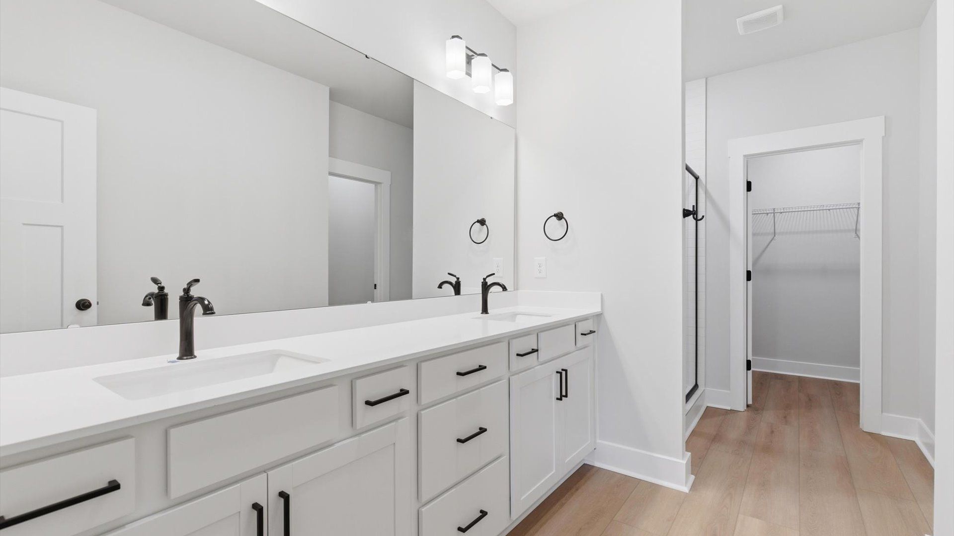 Memorable mornings begin in this elegant primary bathroom with walk-in shower and double vanity