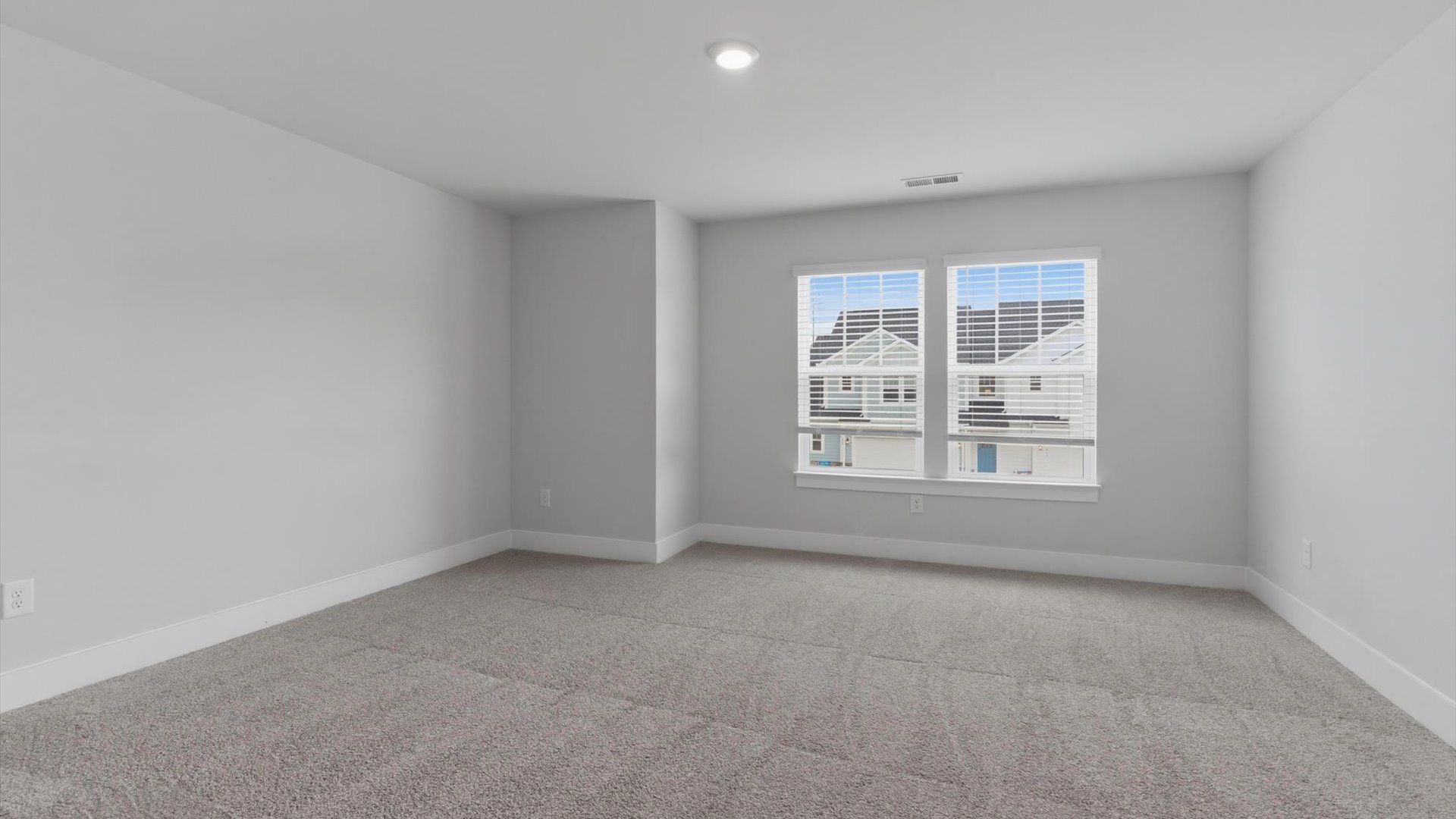 Bright and serene bedroom with comfortable carpeted flooring and large windows for vibrant light in Anderson, SC