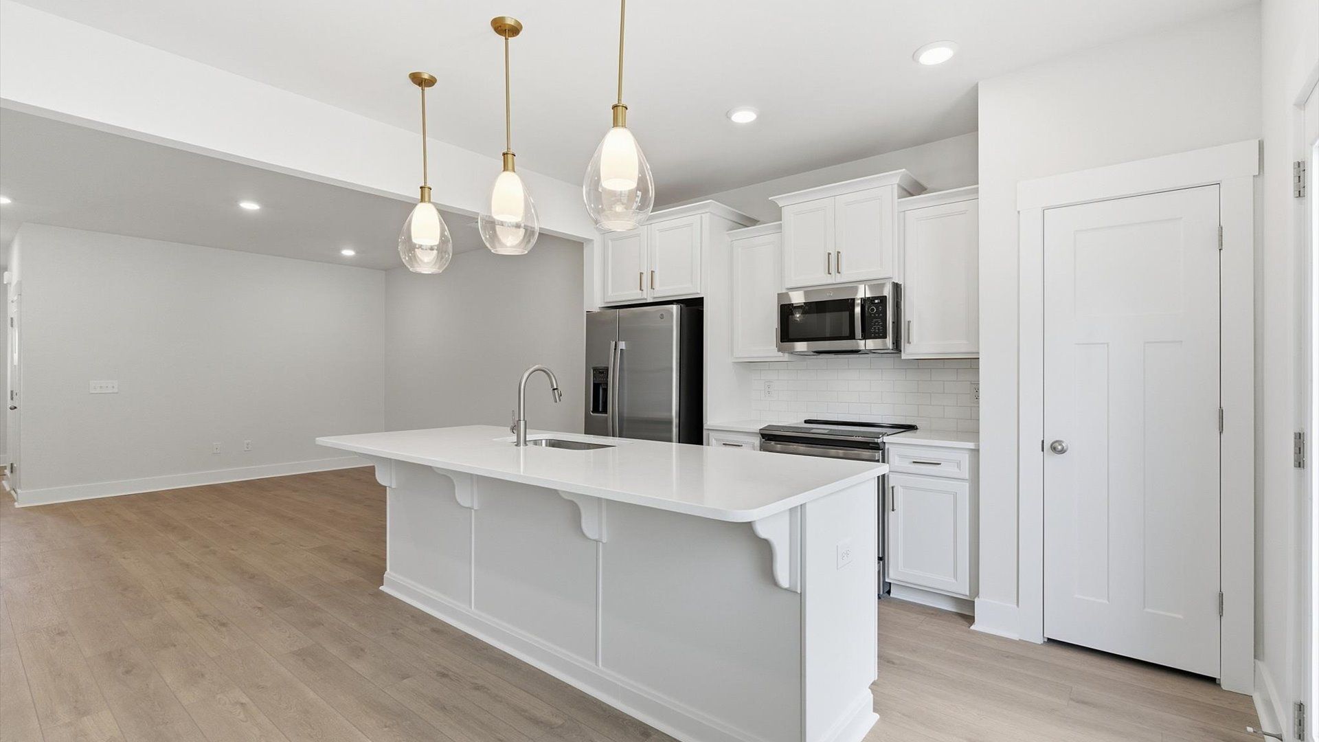 Highly skilled craftsmanship shines in this modern kitchen with pendant lighting and a central island focal point