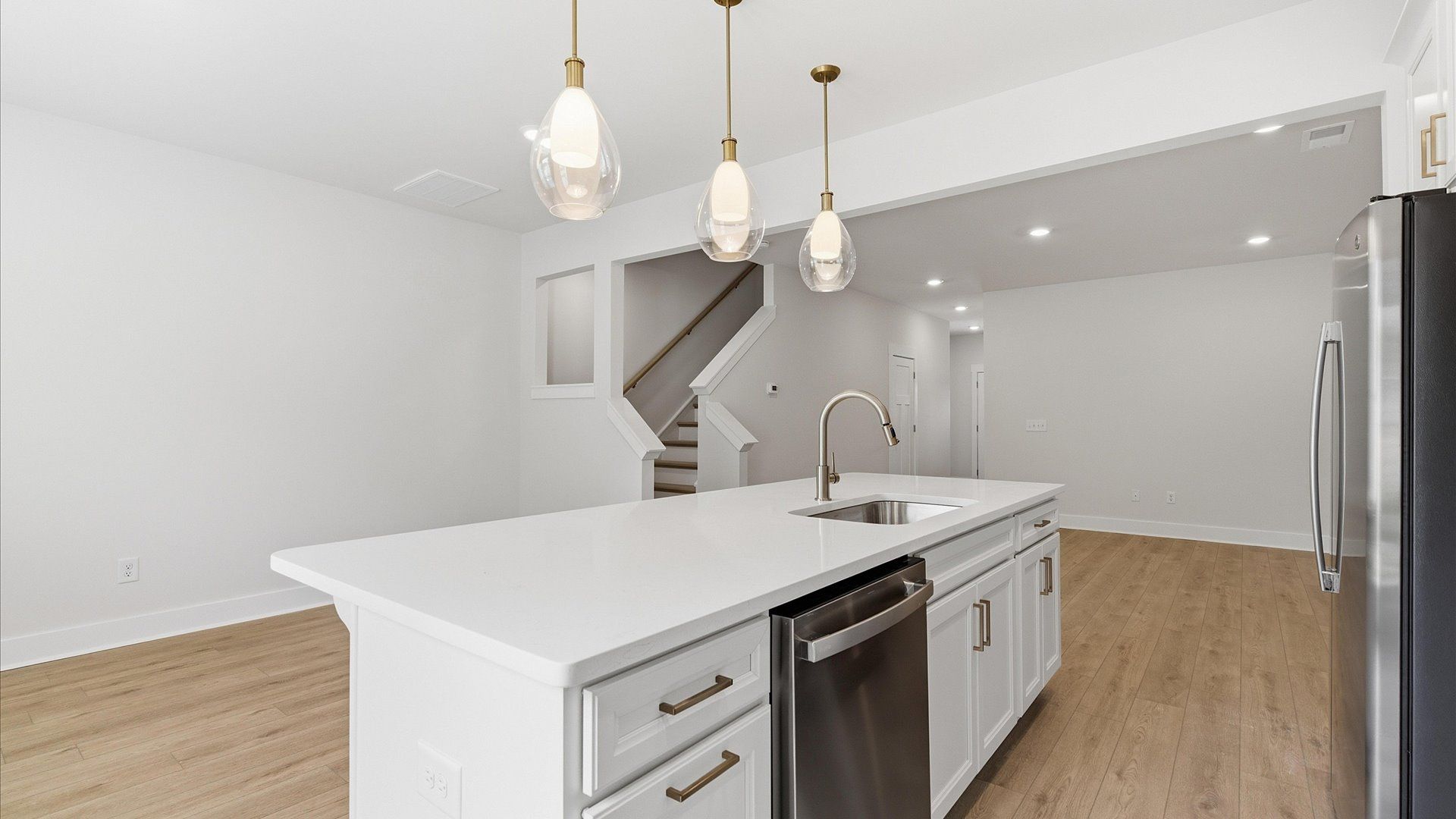 Exceptional kitchen featuring a spacious island, eye-catching pendant lights, and modern finishes located at Gresham Station