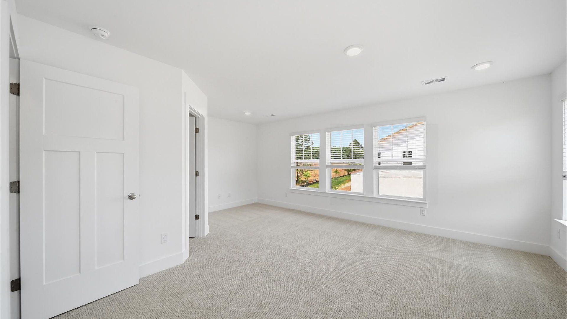 Serene and stylish primary bedroom featuring carpeted flooring and a thoughtful, modern layout in Fountain Inn, SC