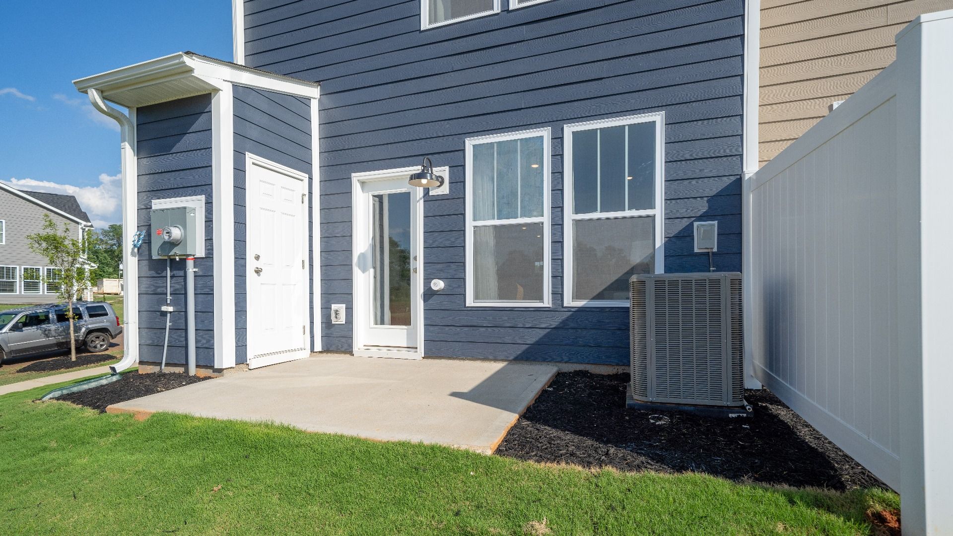Refined rear exterior with a spacious patio for dining, relaxing, or entertaining at Clarke Townes