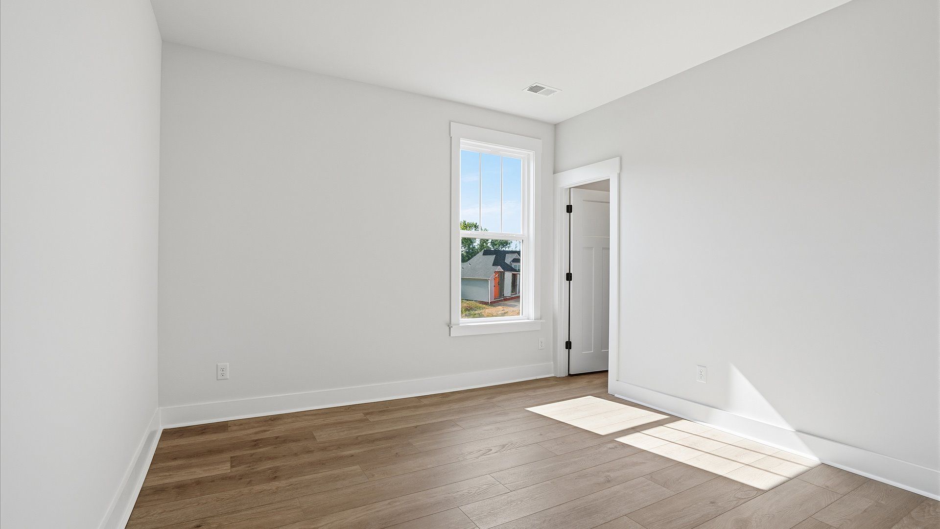 Thoughtfully designed secondary bedrooms featuring hardwood flooring and tasteful detail at Pinebrook