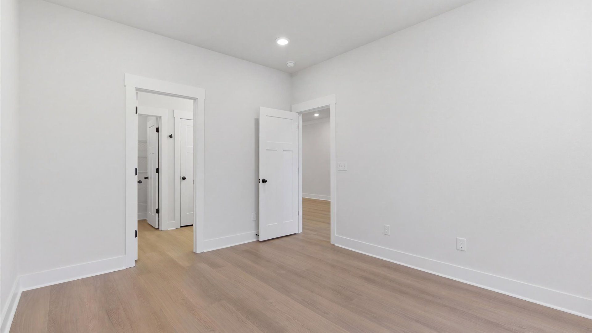 Superior design meets vibrant comfort in this primary suite with hardwood floors and walk-in closet in Greenville, SC