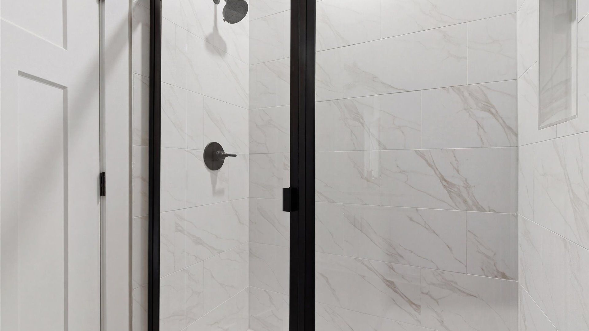 Memorable mornings begin in this elegant primary bathroom with walk-in shower and double vanity