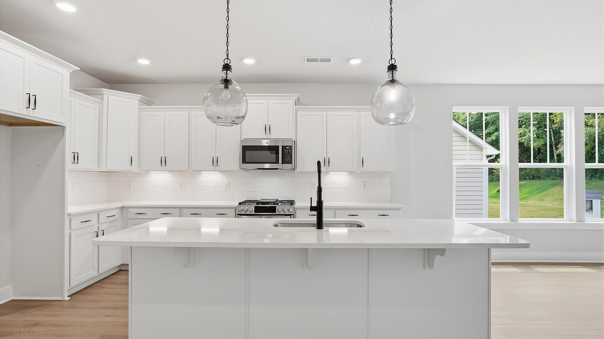 Accomplished kitchen design featuring pendant lighting above a statement island for both prep and gathering