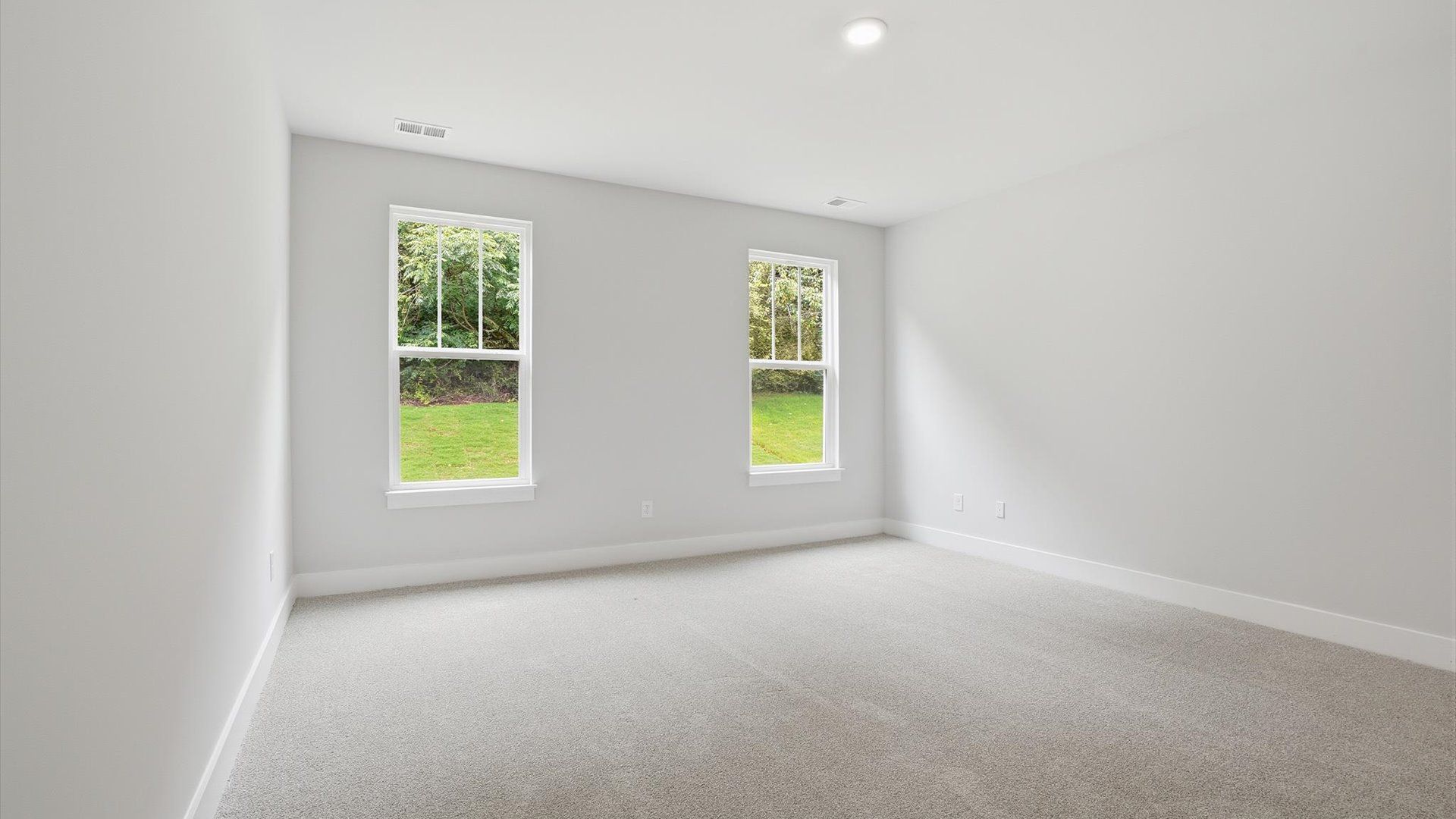 Serene and stylish primary bedroom featuring carpeted flooring and a thoughtful, modern layout