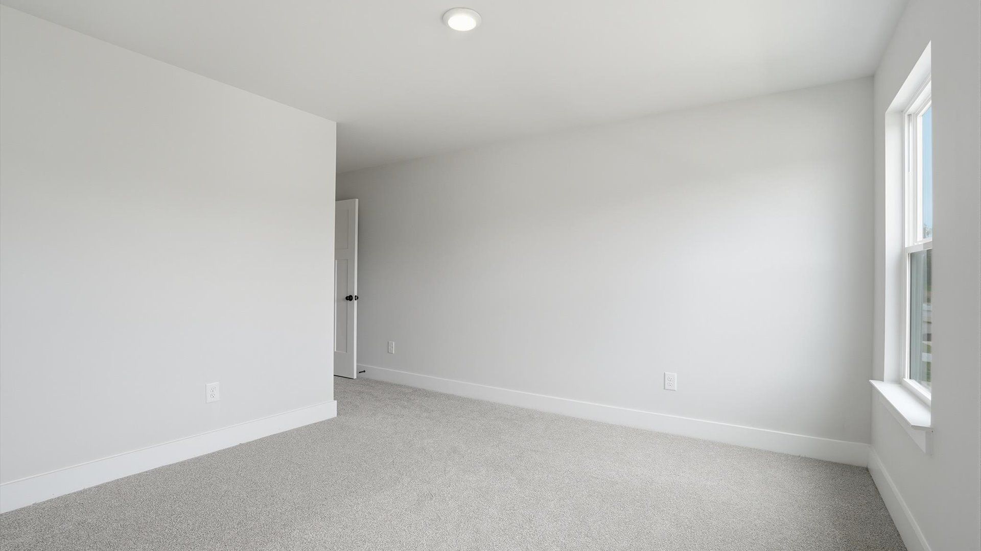 Notable bedroom offering soft carpet, a walk-in closet, and expansive windows overlooking the yard at Creeks at Midway