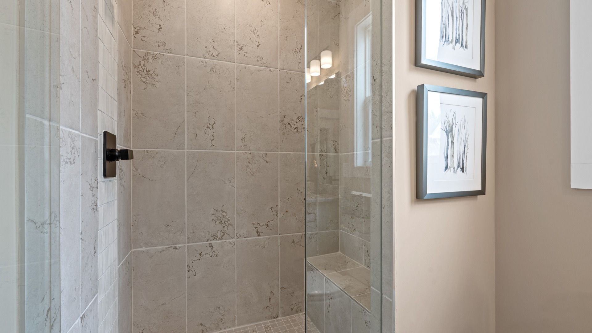 Notable primary bath featuring a glass walk-in shower and tasteful design touches throughout at the Barton Hollow community