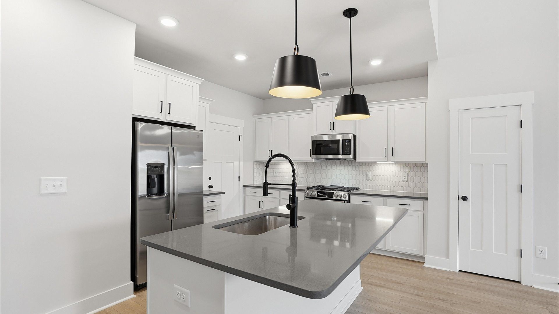 Elegant and compact island anchors this tasteful kitchen with high standards and timeless appeal by DRB Homes