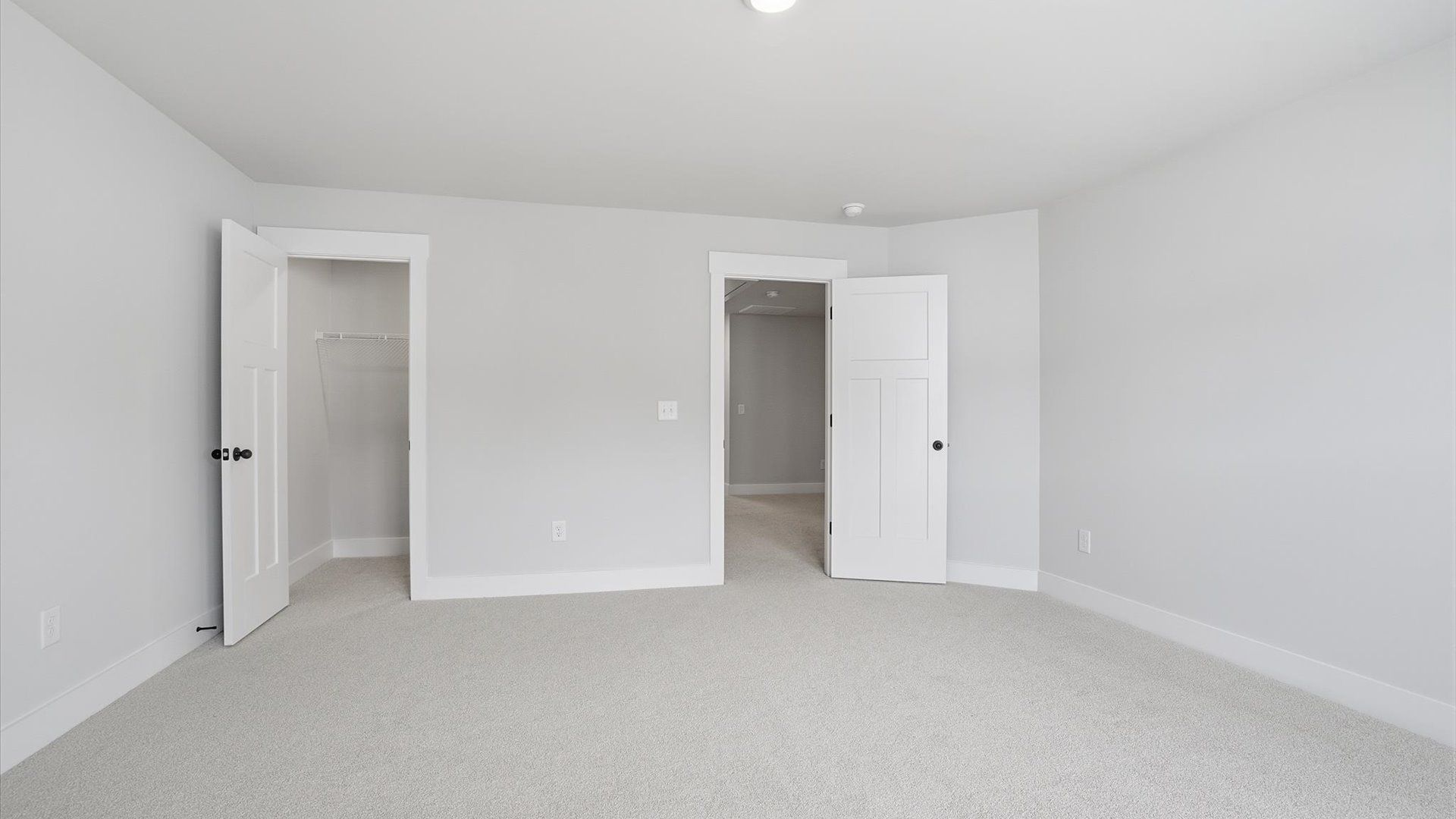 Notable secondary bedroom offering cozy carpeted flooring and a stylish walk-in closet at the Silo Ridge community