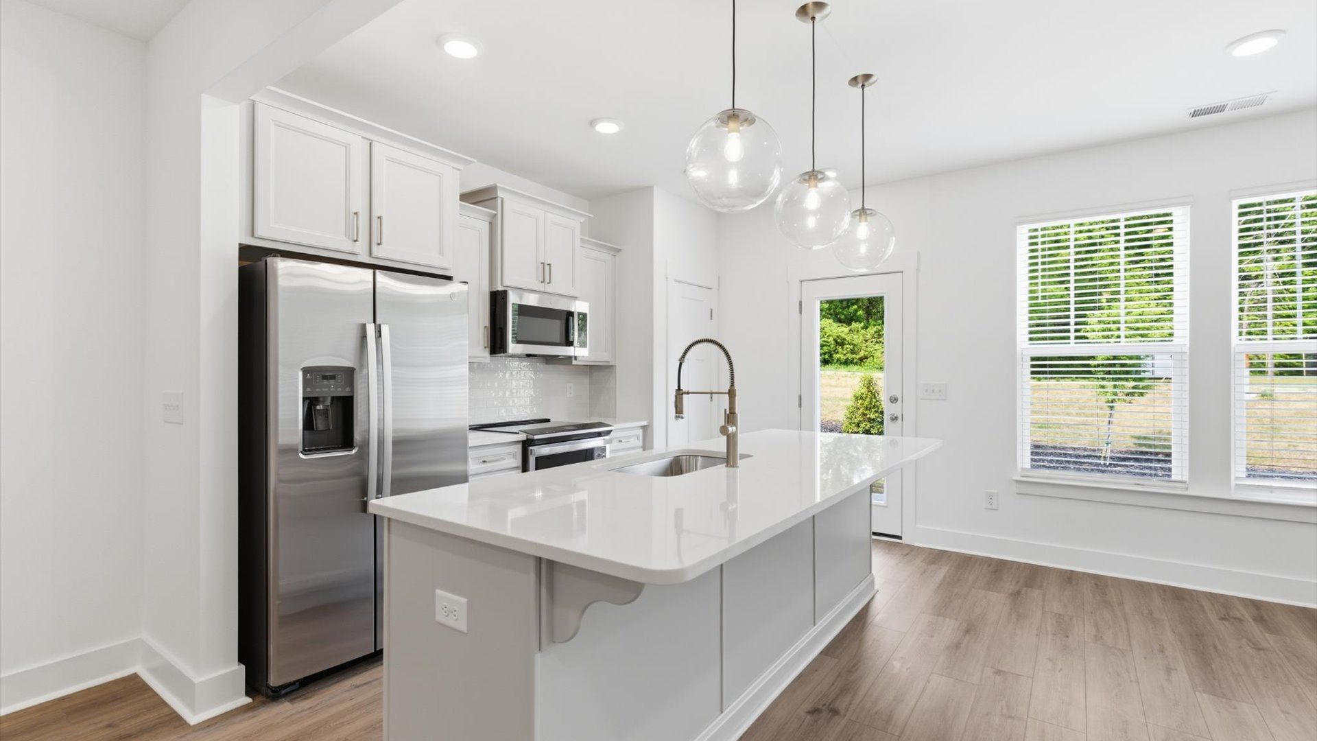 Tasteful kitchen with oversized island and stylish pendant lighting—crafted to high standards at Gresham Station