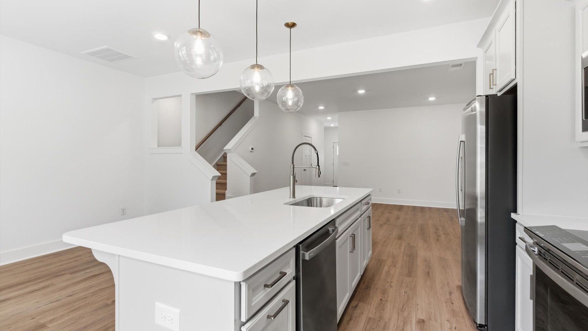 Accomplished kitchen design featuring pendant lighting above a statement island for both prep and gathering in Simpsonville