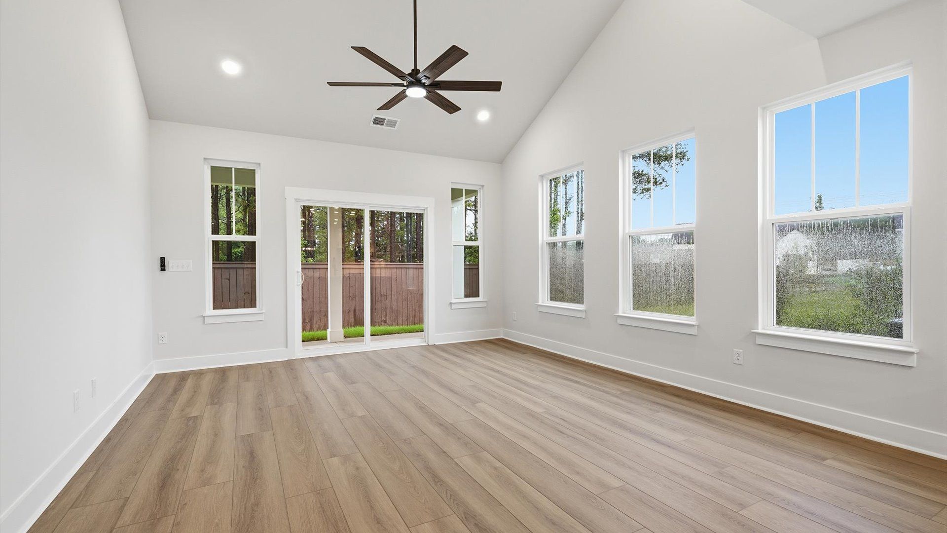 Elegant family room with soaring two-story ceilings and abundant natural light in this first-class DRB Homes design