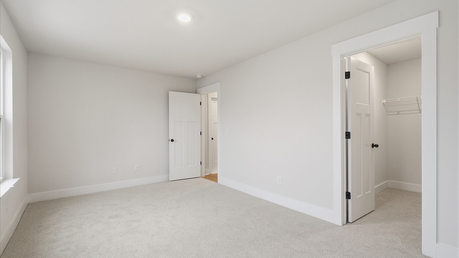 Notable secondary bedroom offering cozy carpeted flooring and a stylish walk-in closet by DRB Homes