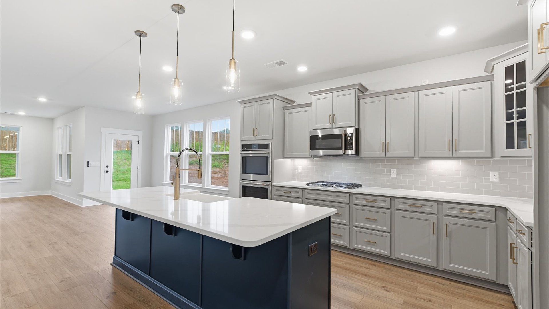 Memorable meals begin in this vibrant kitchen with pendant lighting and a thoughtfully designed island at Woodglen
