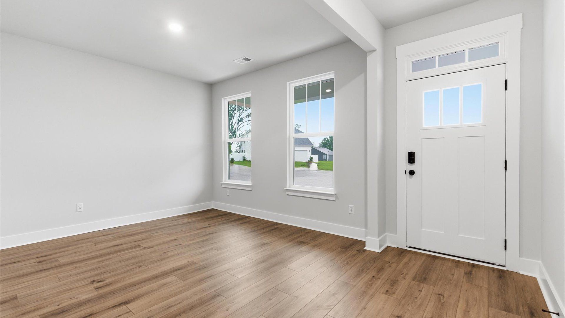 Notable hardwood flooring enhances the elegance of this accomplished entryway at Woodglen