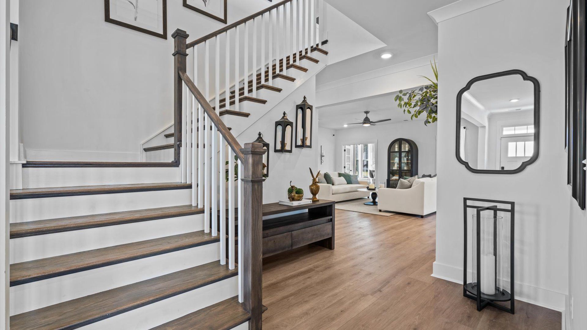 Foyer with hardwood floors, elegant staircase, and an open-concept by DRB Homes