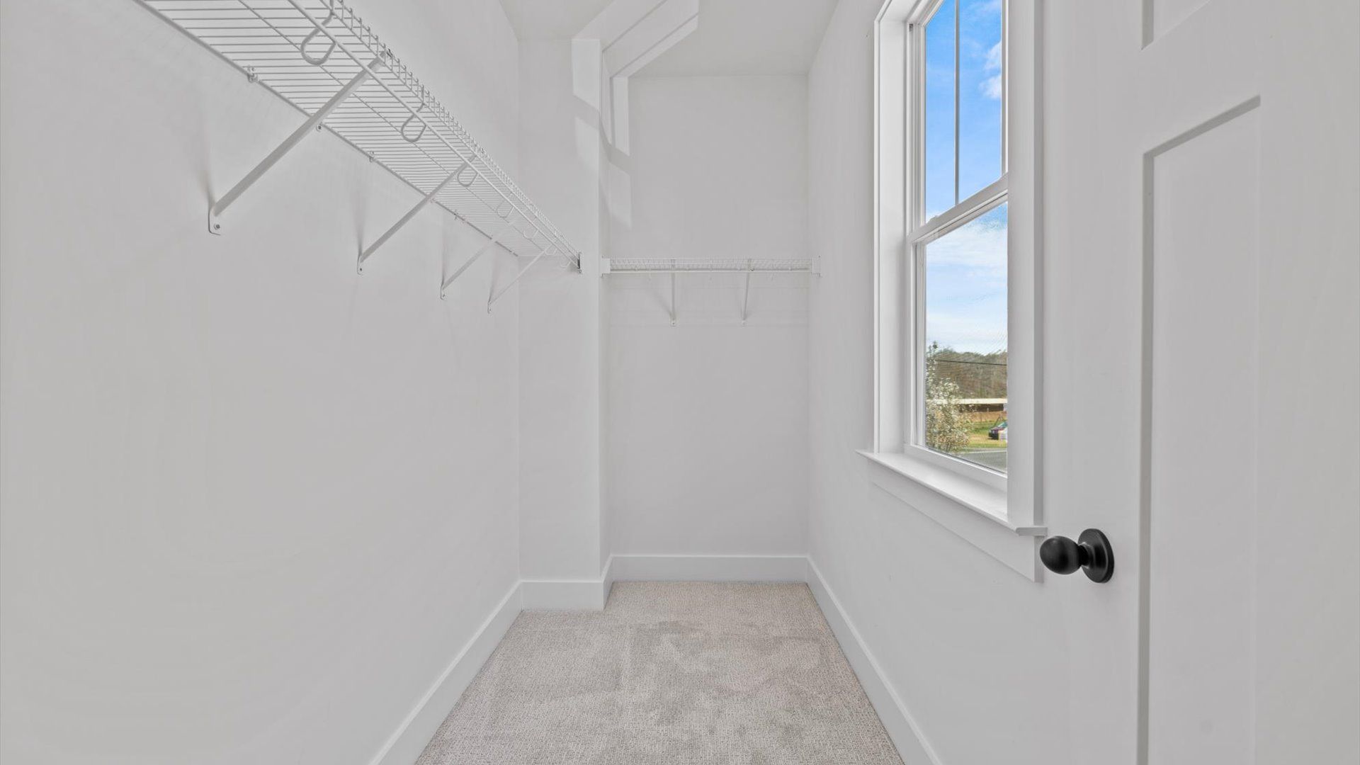 Walk-in closet offering ample storage space and natural light at the Pinebrook community