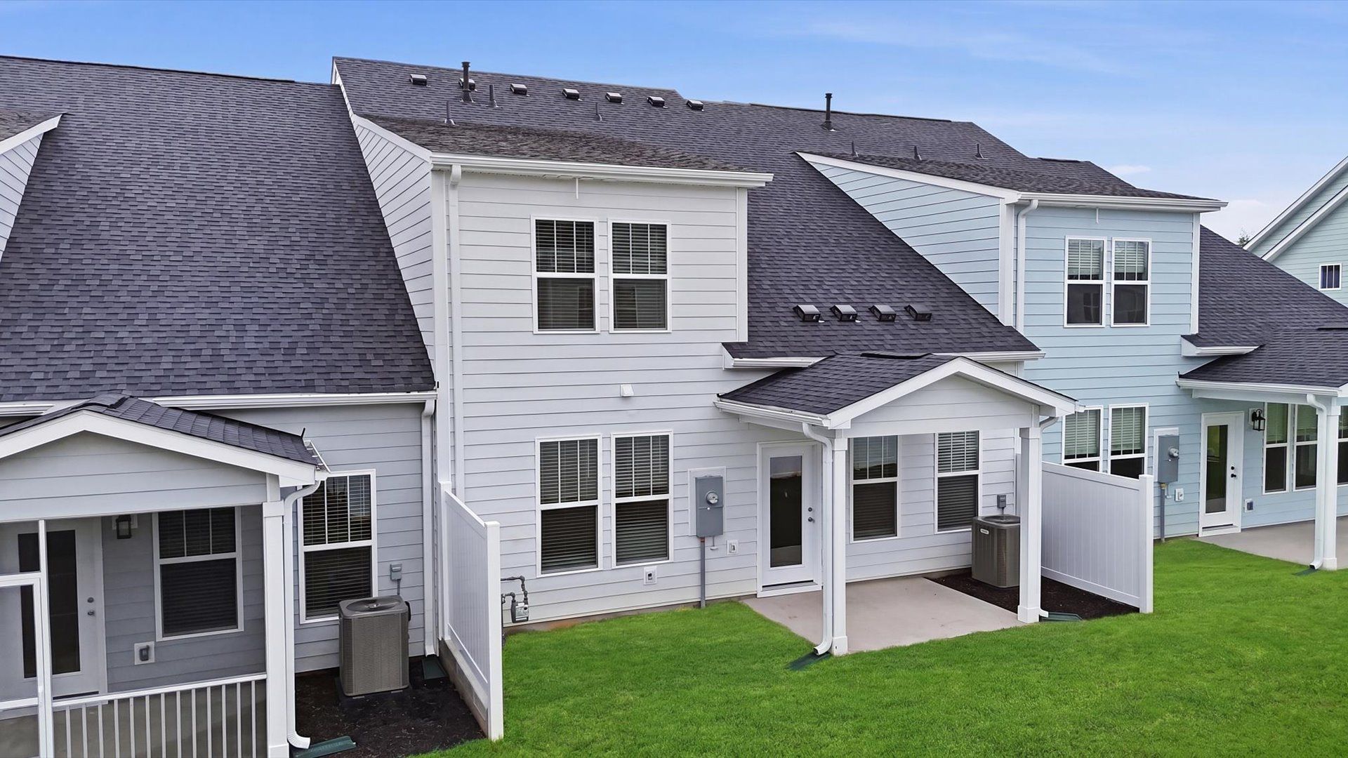 Warm and inviting outdoor living space with a covered rear porch and tasteful finishes at Village at Midway