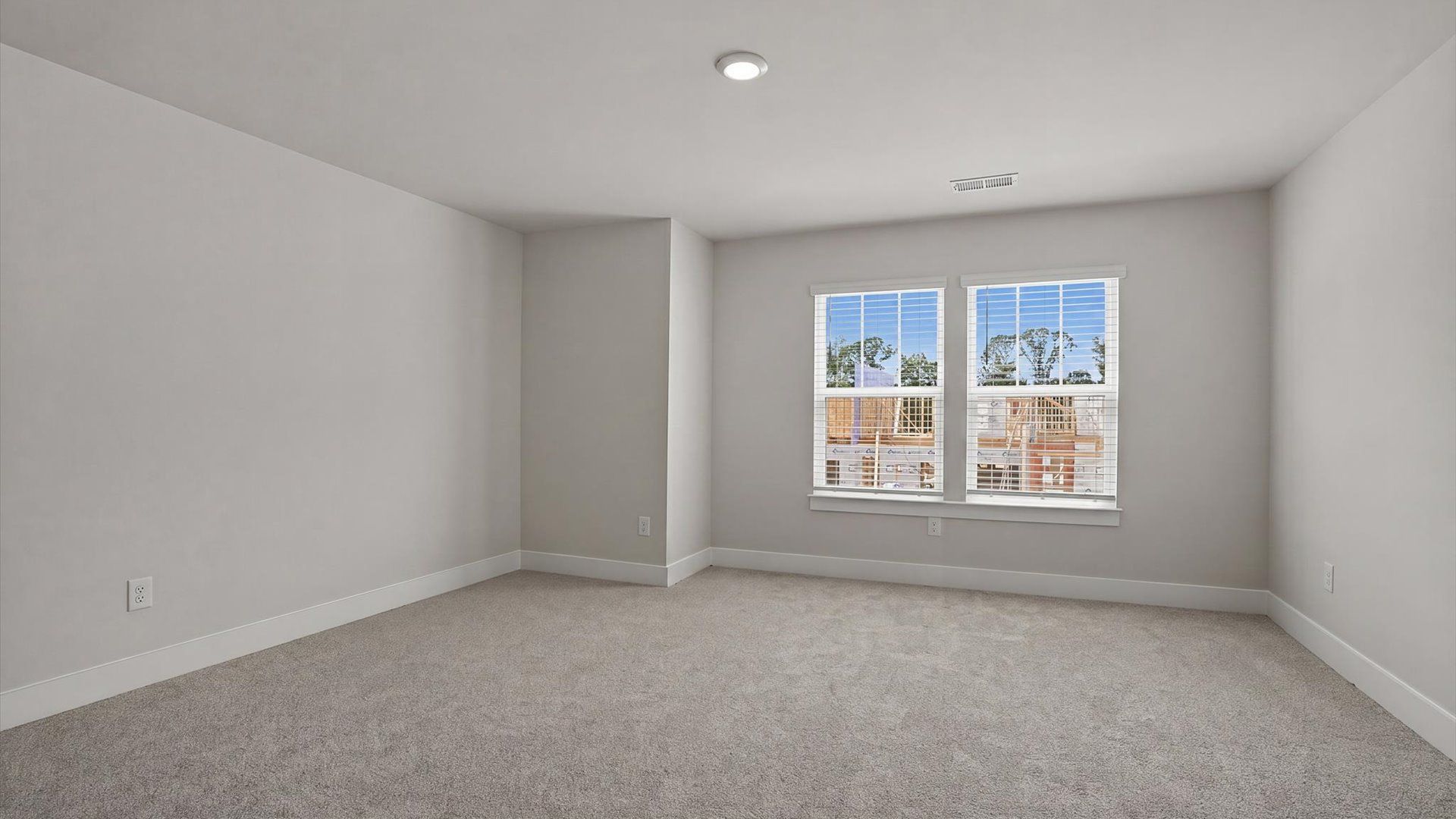 Accomplished design in this restful bedroom featuring plush carpet and oversized window views at Village at Midway