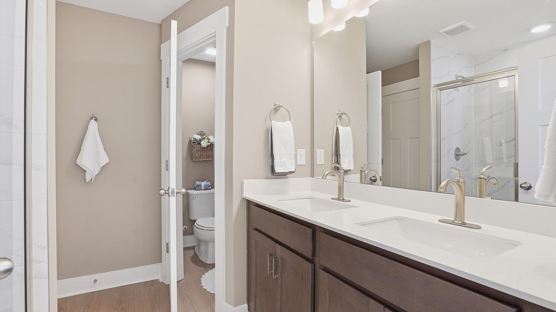 Elegant primary bathroom featuring a spacious walk-in shower and dual vanity in this first-class DRB Homes design