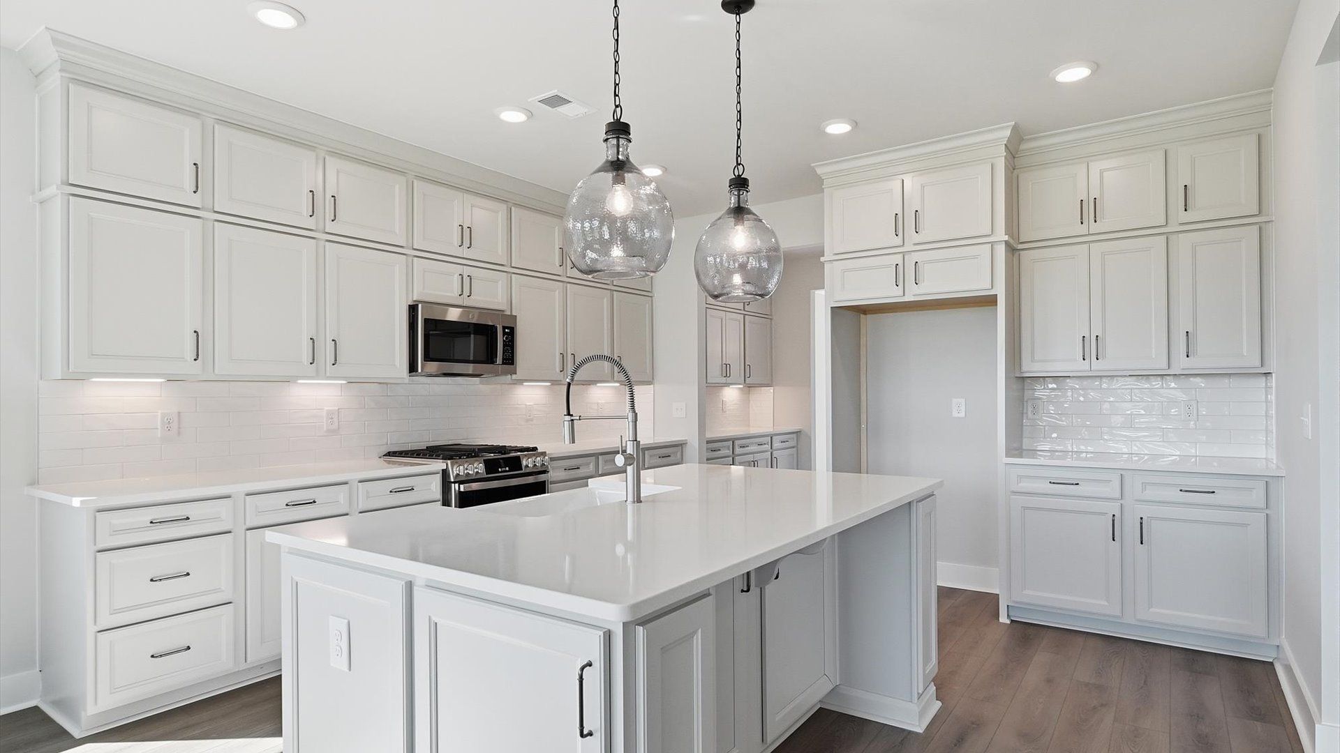 Elegant island anchors this tasteful kitchen with high standards and timeless appeal by DRB Homes