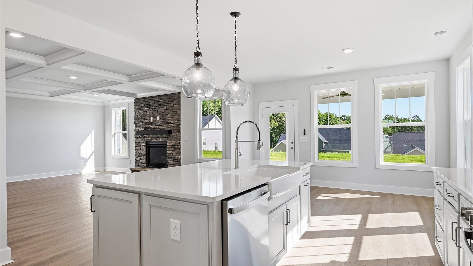 Highly skilled kitchen design includes a 9-foot island, quartz countertops, and stylish pendant fixtures by DRB Homes