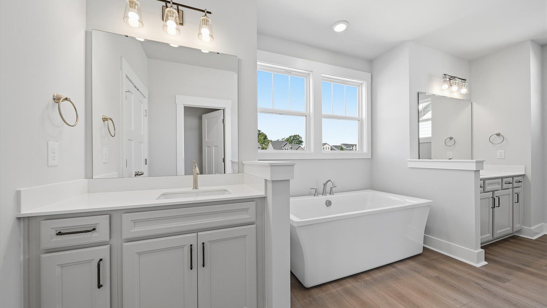 Elegant primary bathroom featuring a soaking tub and dual vanities in this first-class DRB Homes design
