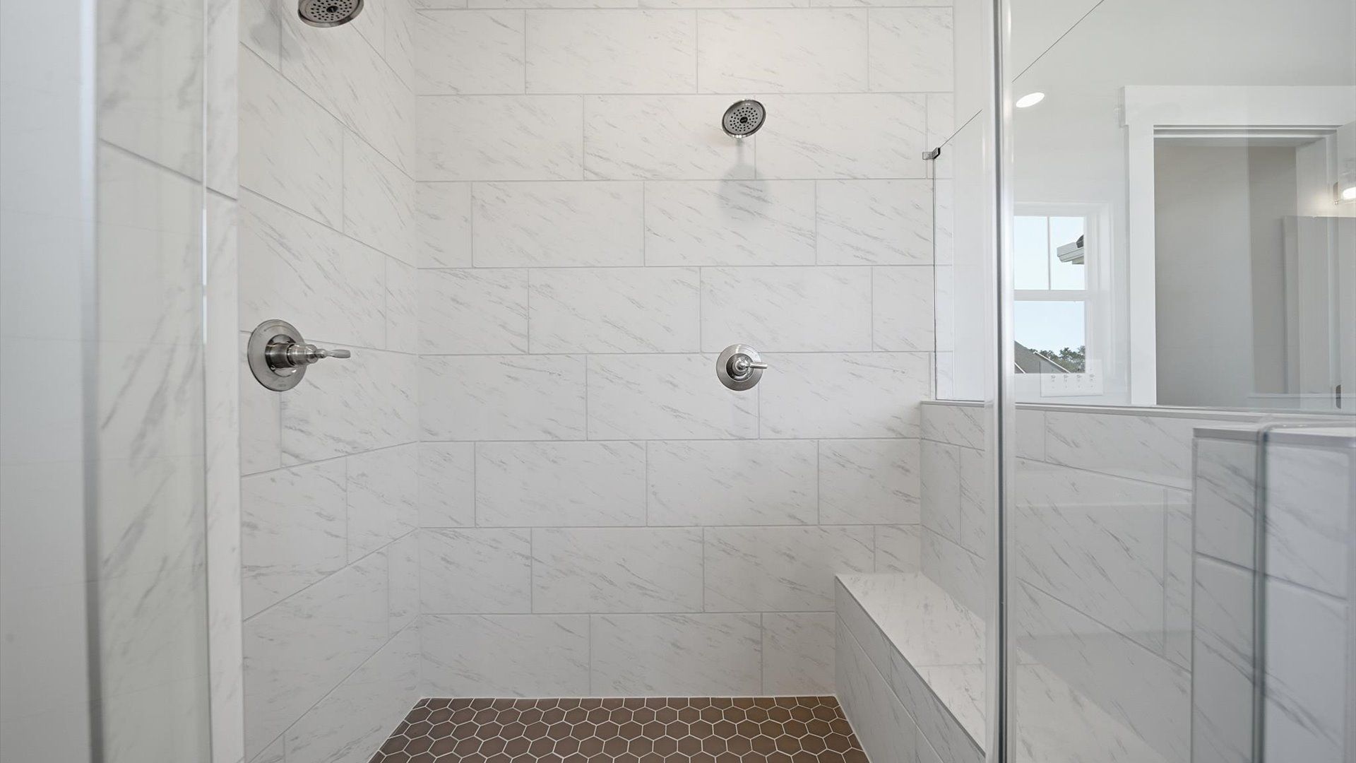 Memorable mornings begin in this elegant primary bathroom with a large walk-in shower and natural light in Anderson, SC