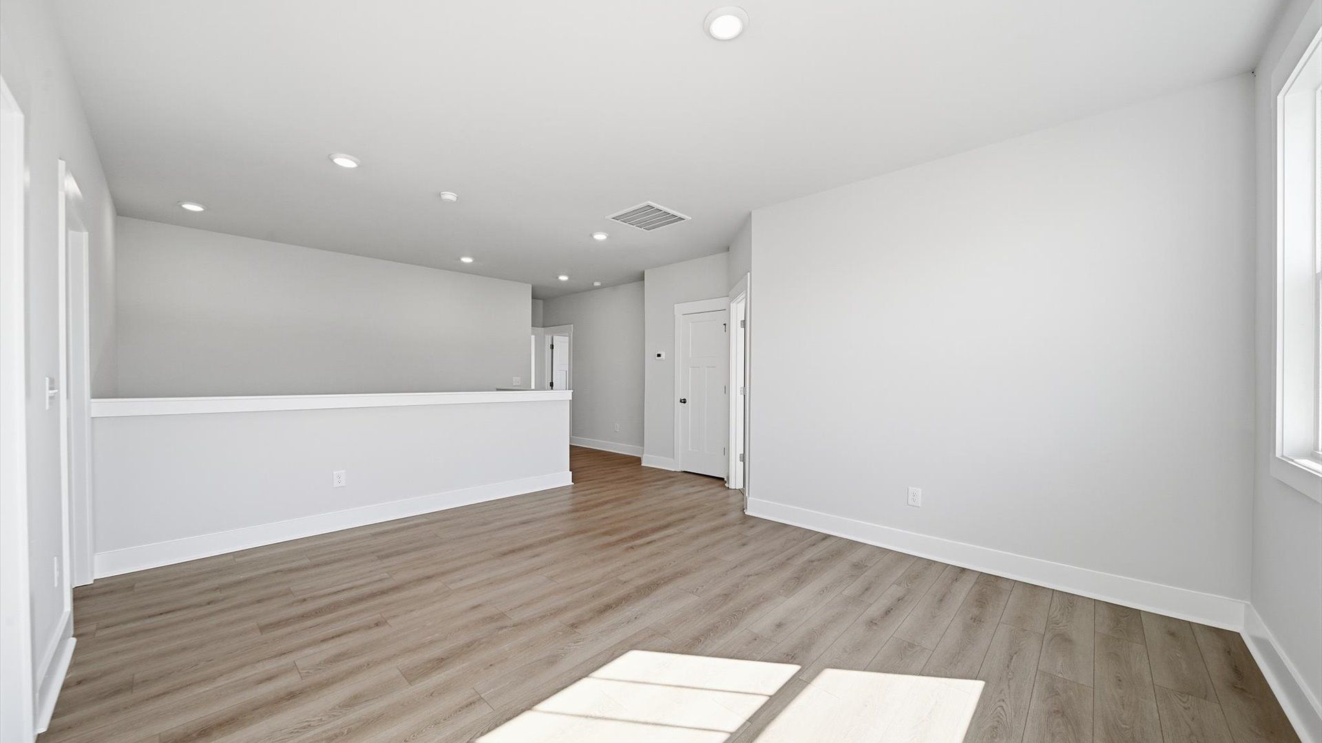 Functional loft with tasteful hardwood floors and exceptional natural light in a modern home