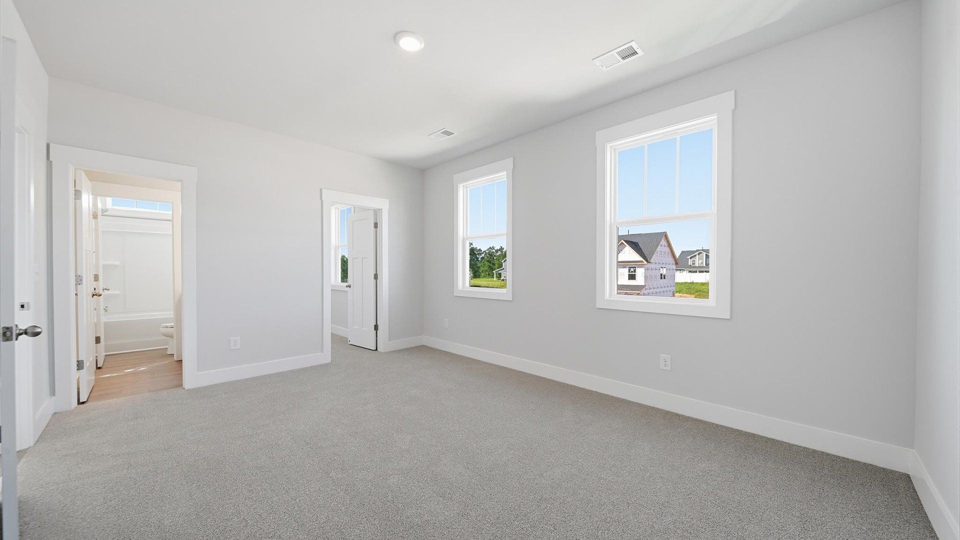 Highly functional bedroom with large windows, carpeted flooring, and tasteful finishes throughout in Anderson, SC