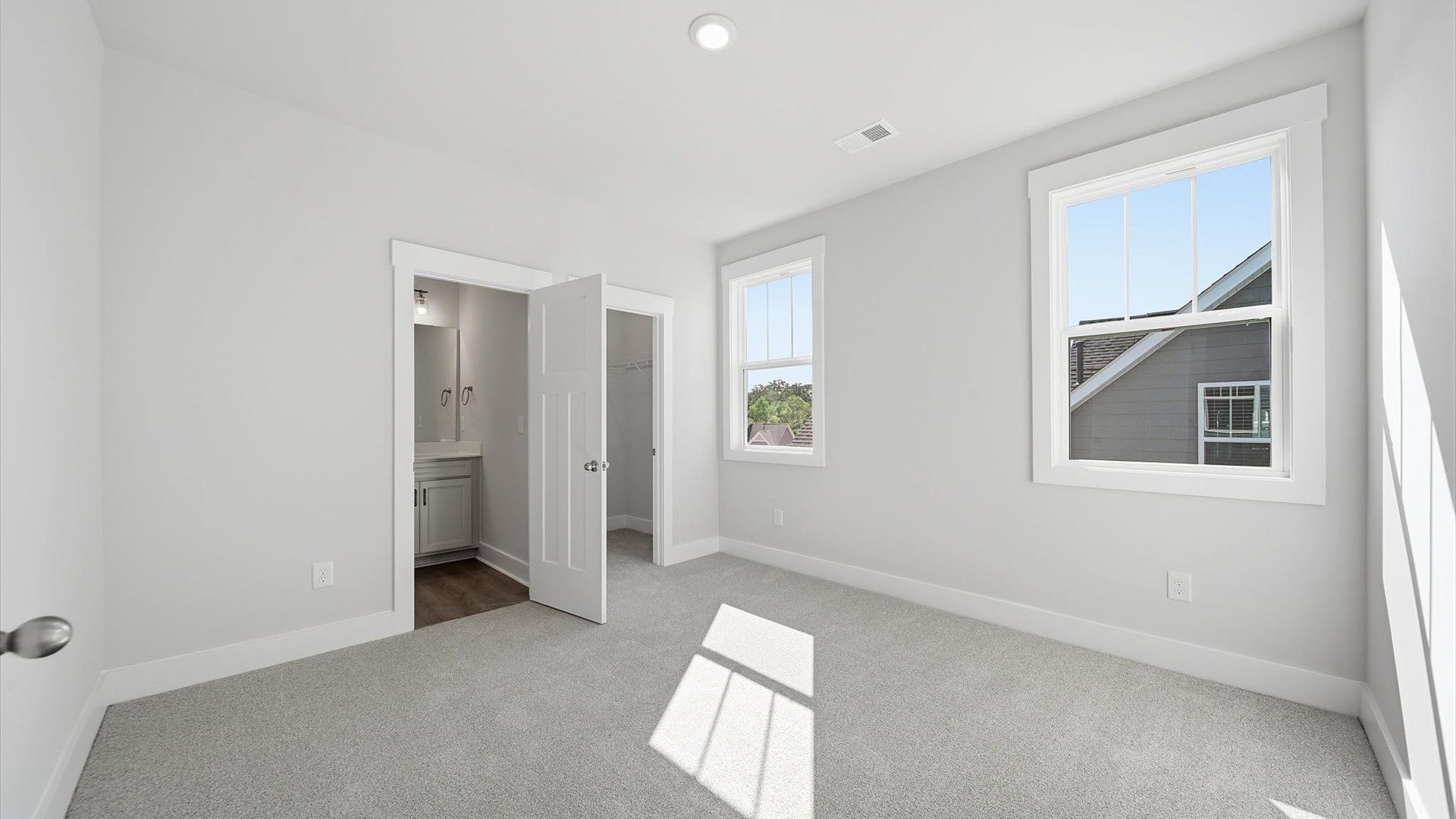 First-rate bedroom with plush carpeting and large windows that provide an open, airy feel by DRB Homes