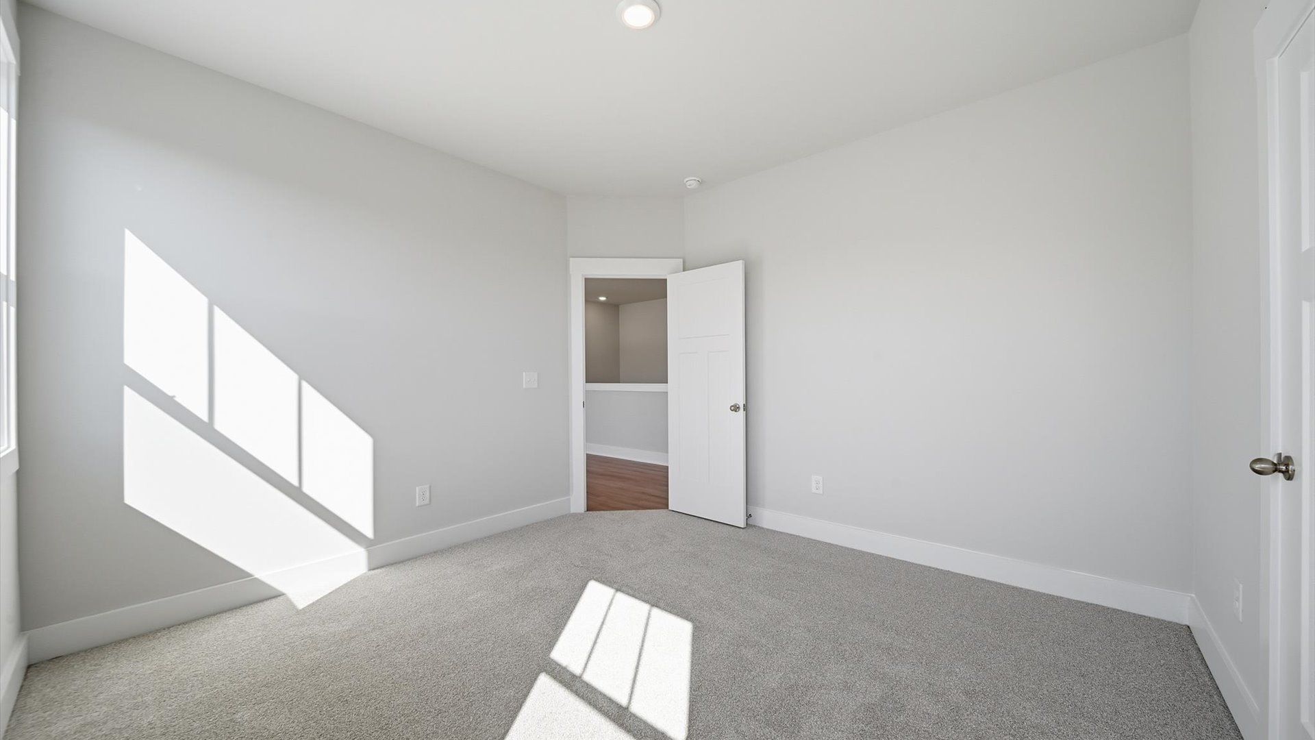First-rate secondary bedroom with a spacious walk-in closet and elegant carpeted flooring at Kayfield at Midway