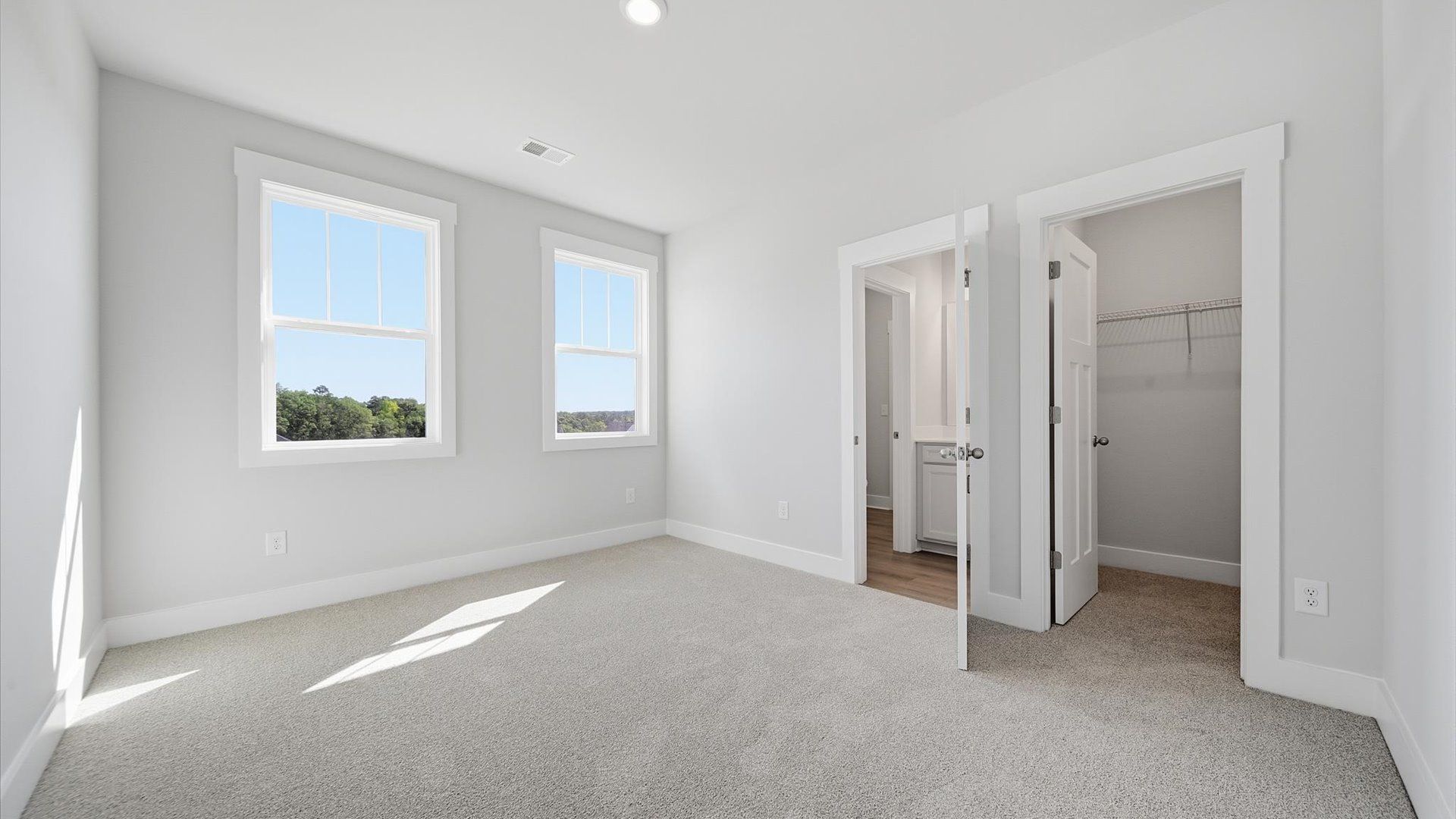 Inviting bedroom with tasteful finishes and large windows that create a fresh, open ambiance at Kayfield at Midway