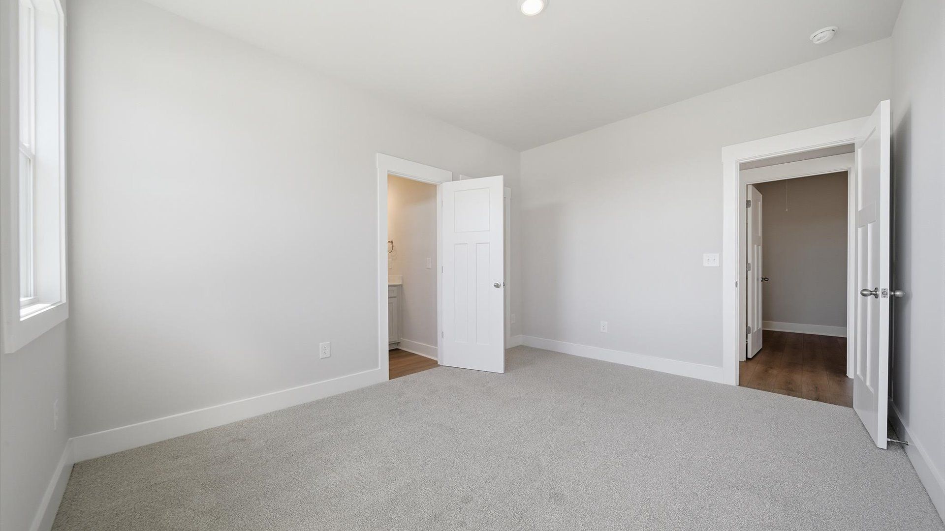 Superior comfort in this light-filled bedroom with plush carpeting and thoughtfully placed large windows