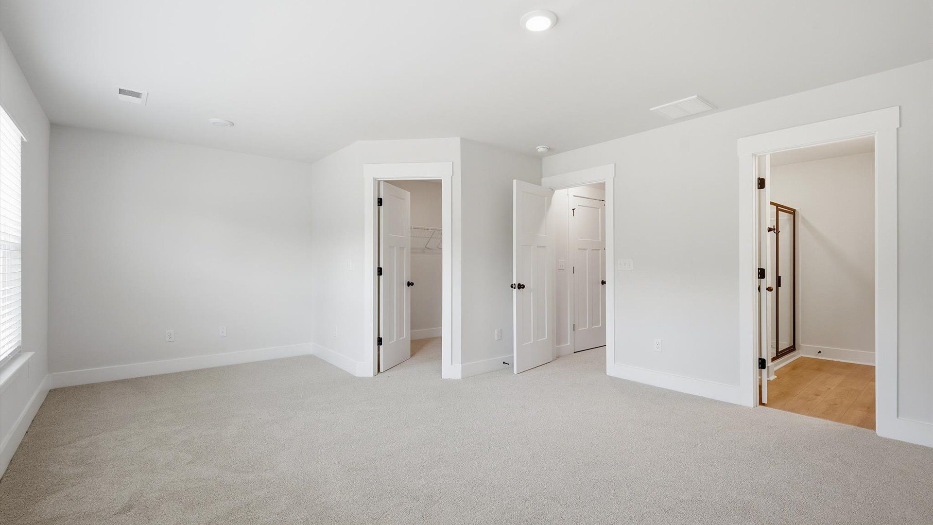 Superior design meets vibrant comfort in this primary suite with carpeted floors and walk-in closet in Greenville, SC